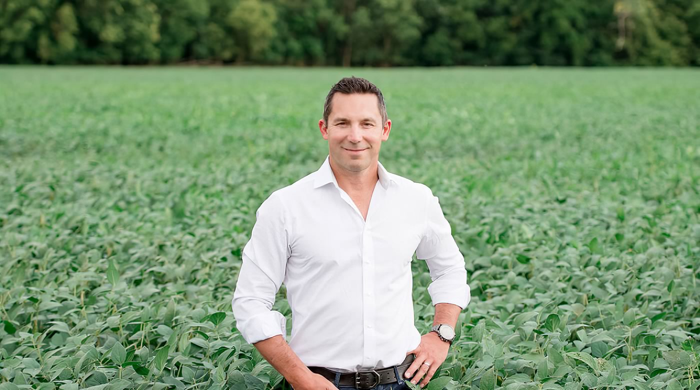 Crescero Natural Capital team member stands in a dense crop field of soy | Crescero Natural Capital